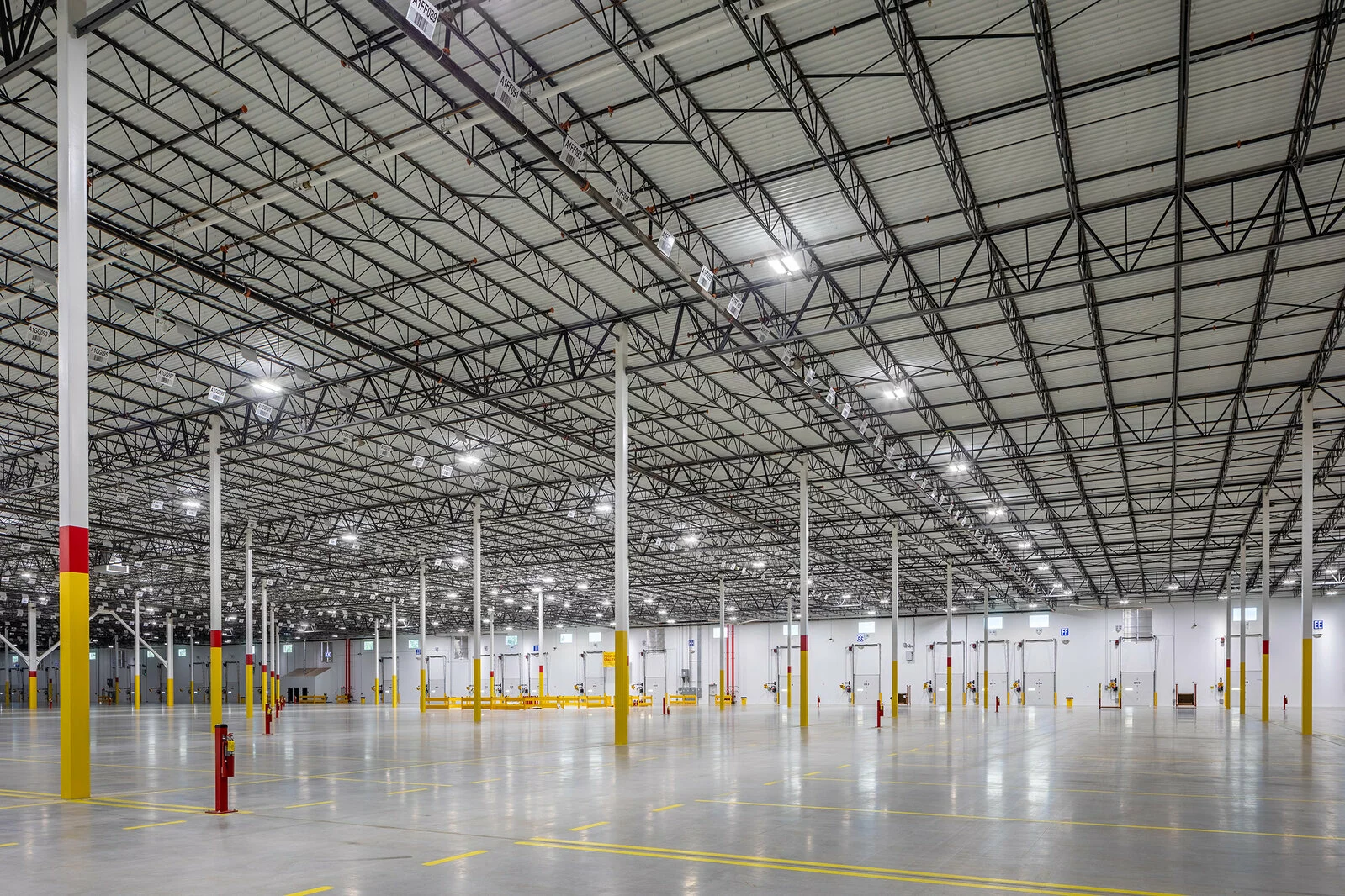 project fireball large interior of facility, red and yellow beams, bright lights, flooring with yellow markings.