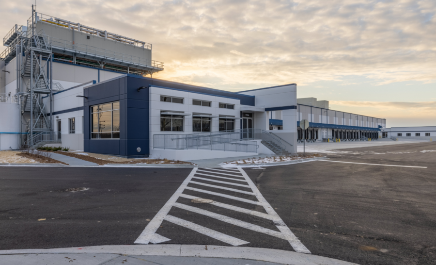 Exterior Cold Summit building, ramp leading to front entrance, countless distribution bays in background, photo taken at sunset.
