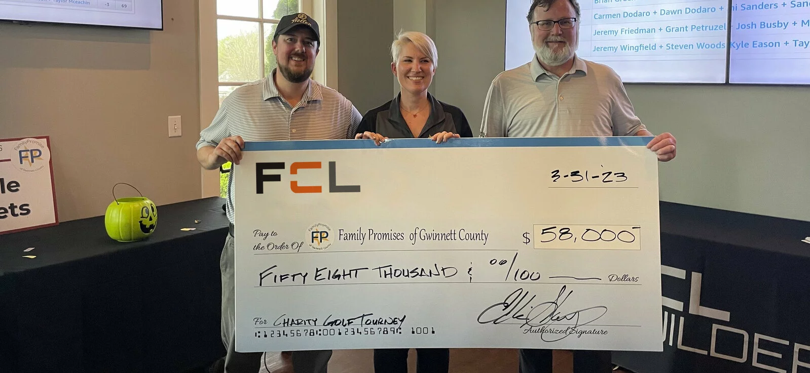 FCL Team Members holding a giant check for $58,000