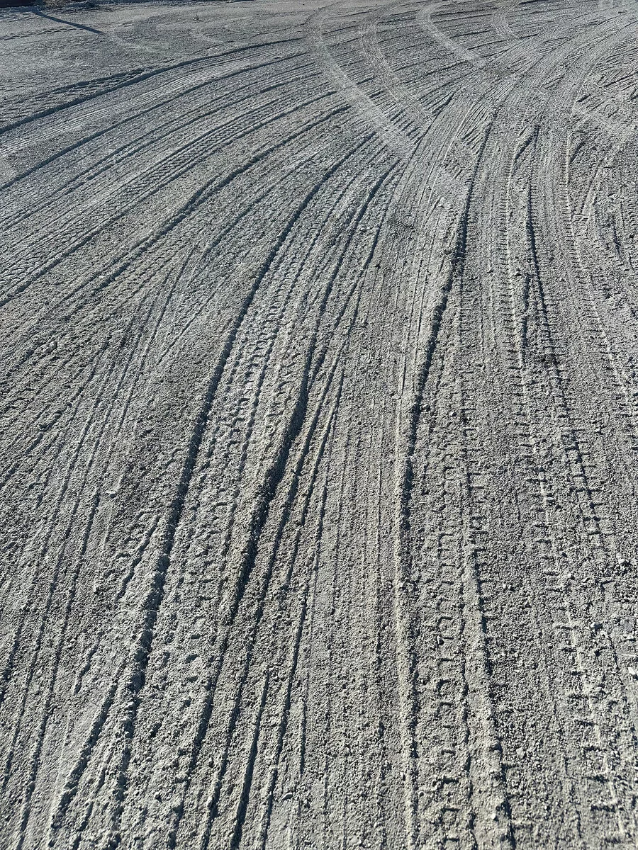 Photo of tire tracks across dirt.