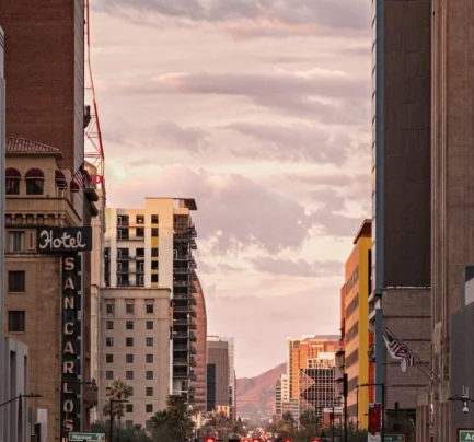 Photo of city street taken between high rise buildings, Photo taken at sunset.
