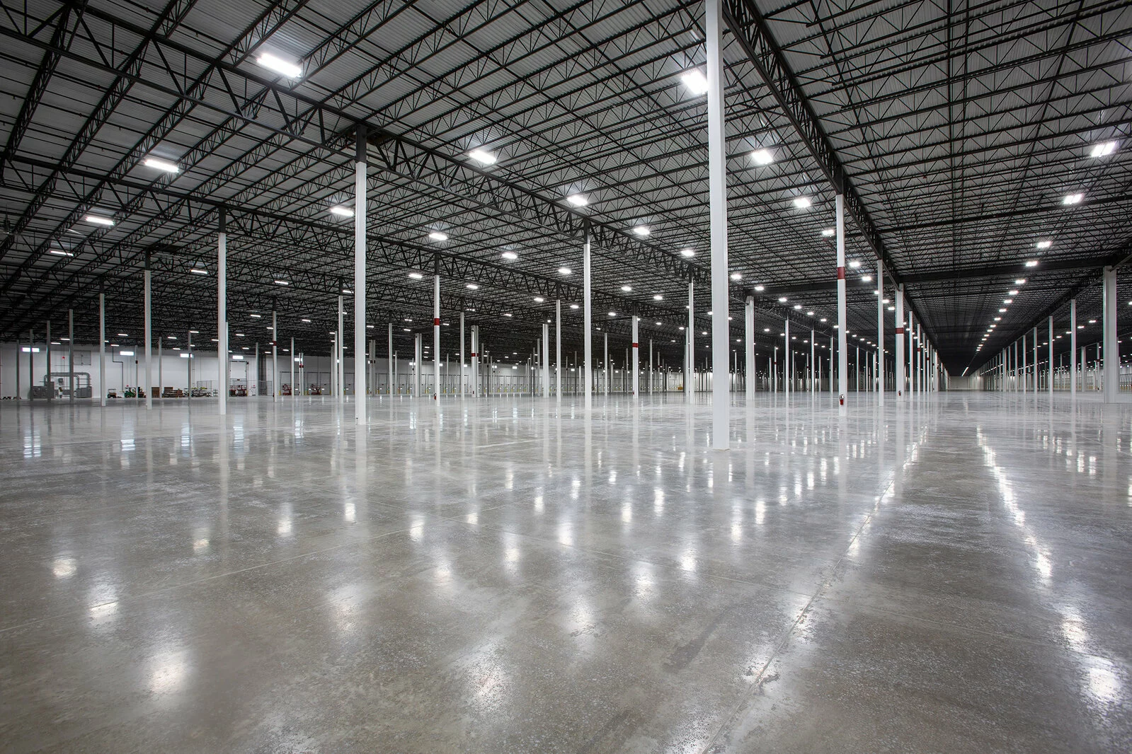 interior warehouse, countless white columns vast empty space, concrete floors.