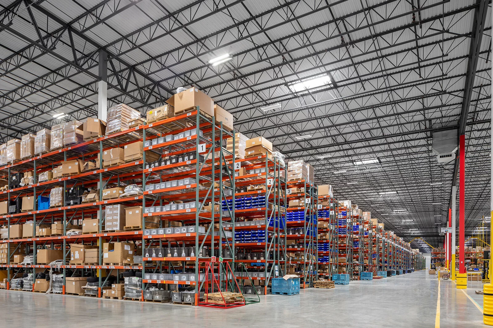 interior storage and distributions facility, countless rows of industrial storage racks, concrete floors.