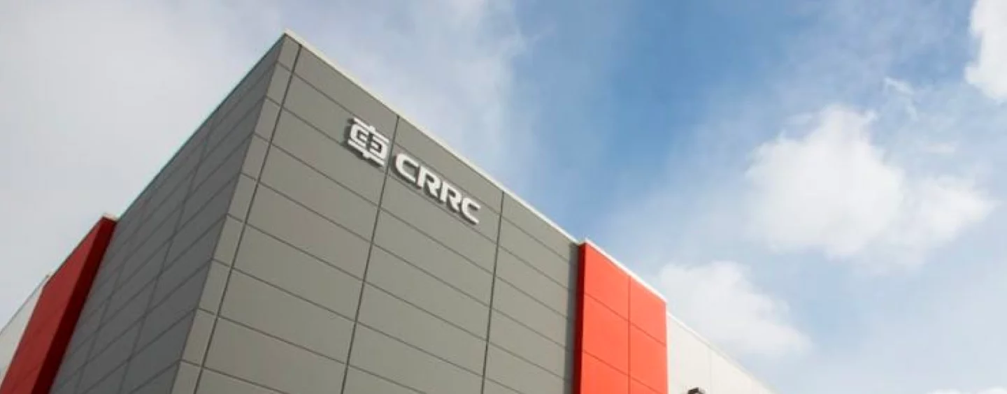 Exterior CRRC Facility, photo looking up at signage on top of building, photo taken on a sunny day with clouds.