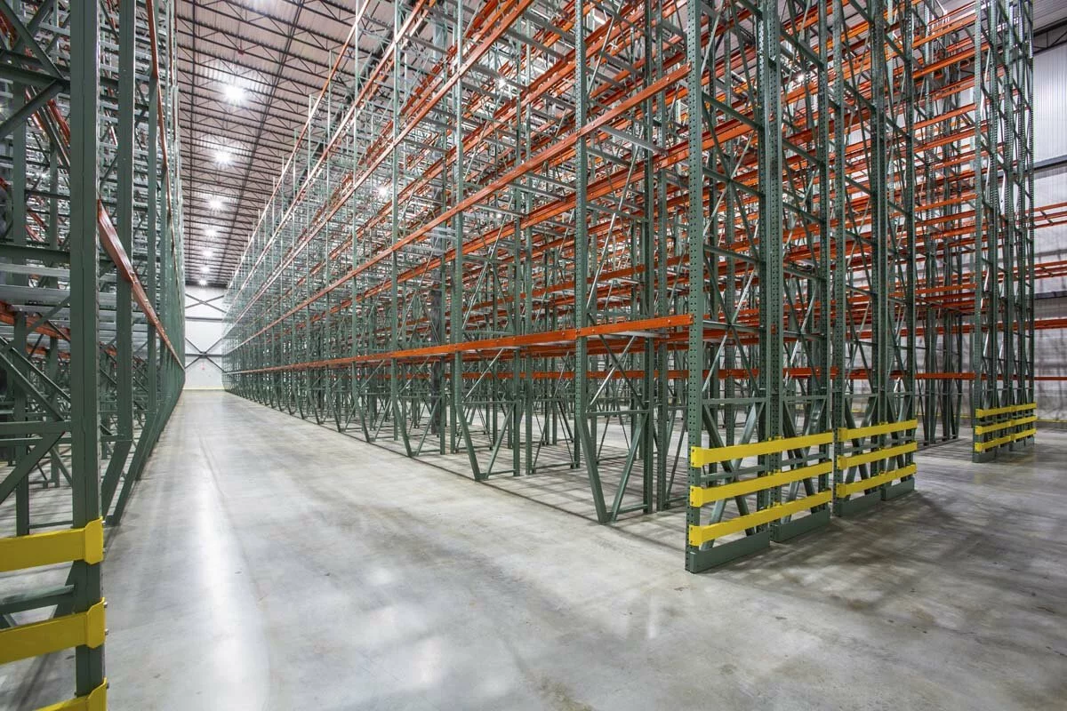 McCook Cold Storage interior facility, rows of dense red and green racks, tall ceilings, bright ceiling lights.
