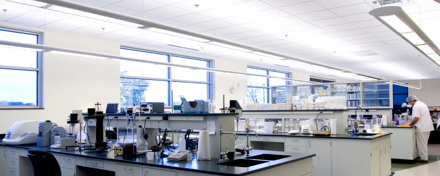 life sciences lab, bright room with science equipment, large windows, lab scientist working.