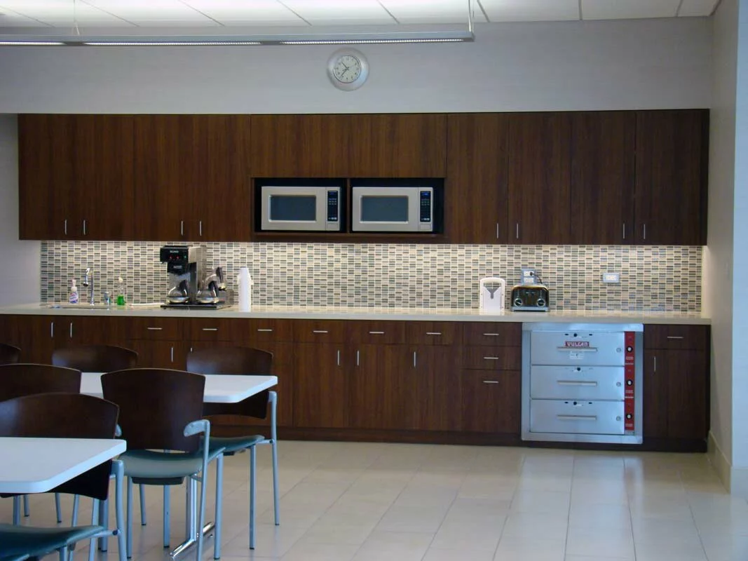 Michael Lewis interior kitchen room, 2 microwaves, sink, cabinets, Vulcan warming drawers, and lunch tables.